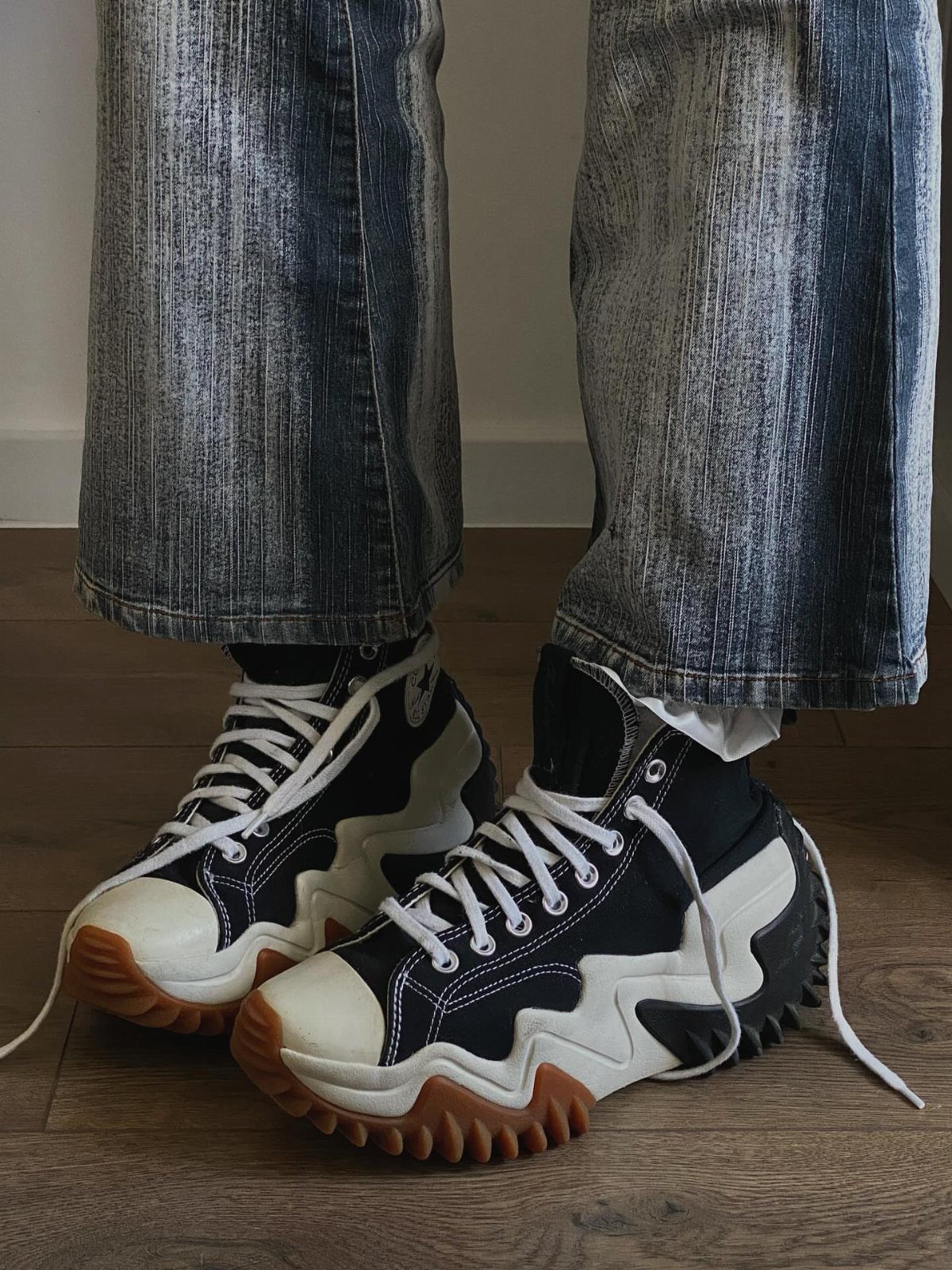 Black and white Converse Run Star Motion platform sneakers worn with acid-wash denim jeans.
