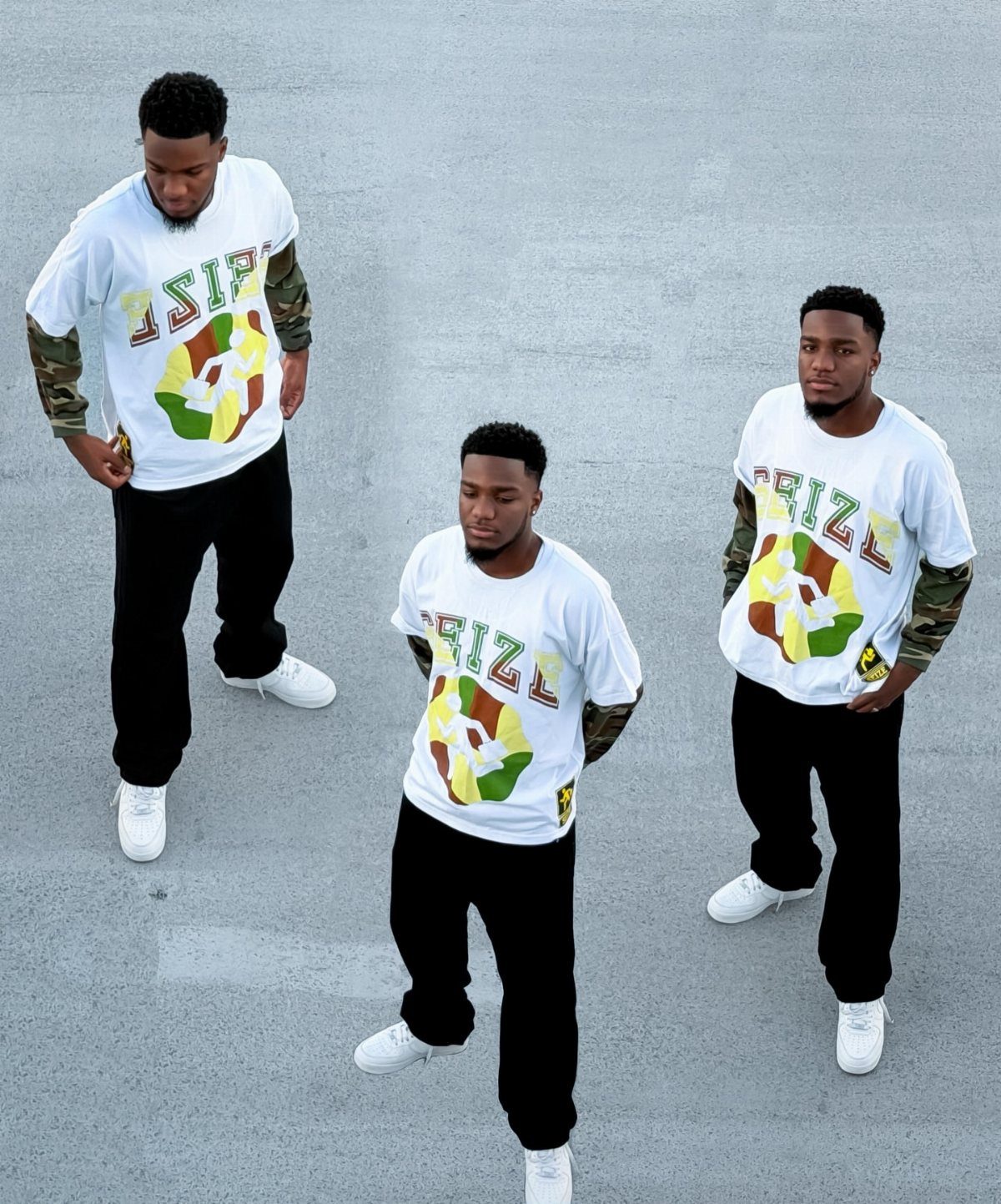 Three men wearing matching white graphic t-shirts with camouflage sleeves and black pants.